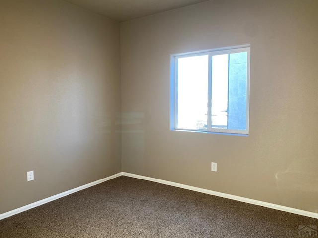 empty room featuring baseboards and carpet