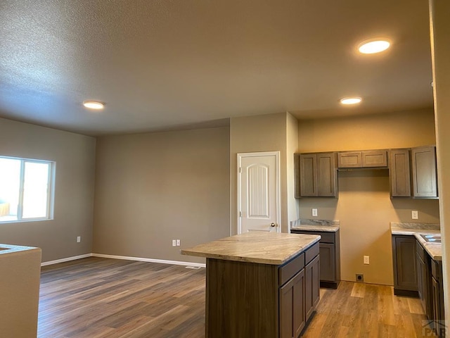 kitchen featuring light countertops, dark wood-style floors, baseboards, and a kitchen island