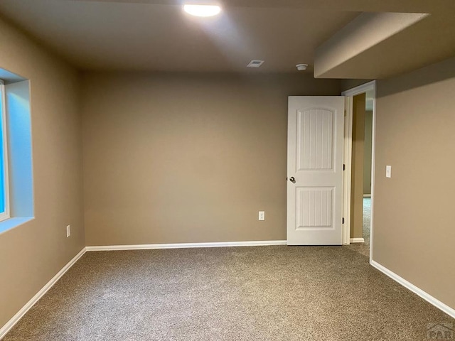 empty room with baseboards, carpet floors, and visible vents