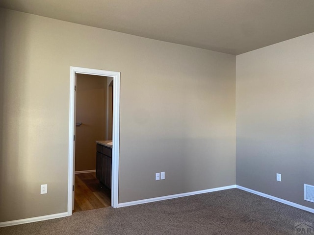 spare room featuring baseboards, visible vents, and carpet floors