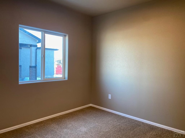 spare room featuring baseboards and carpet