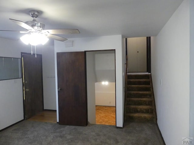 unfurnished bedroom with dark carpet and a ceiling fan