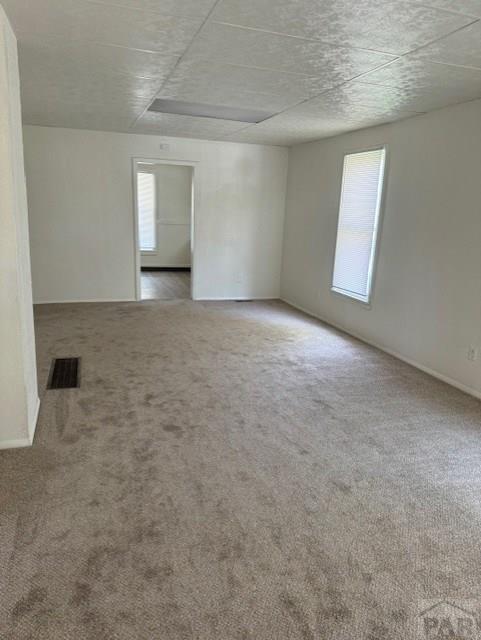 carpeted empty room with visible vents