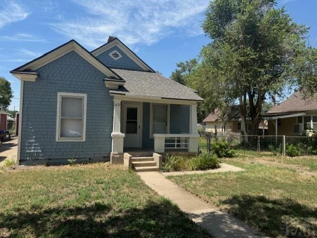 bungalow-style home with crawl space, fence, a porch, and a front yard