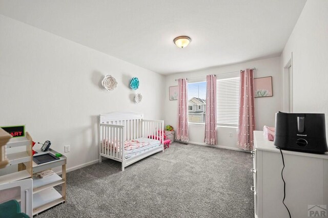 carpeted bedroom with a nursery area and baseboards