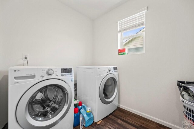 laundry area with laundry area, separate washer and dryer, dark wood-style flooring, and baseboards