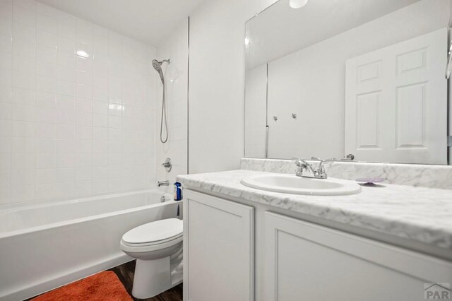 full bath featuring wood finished floors, shower / tub combination, vanity, and toilet