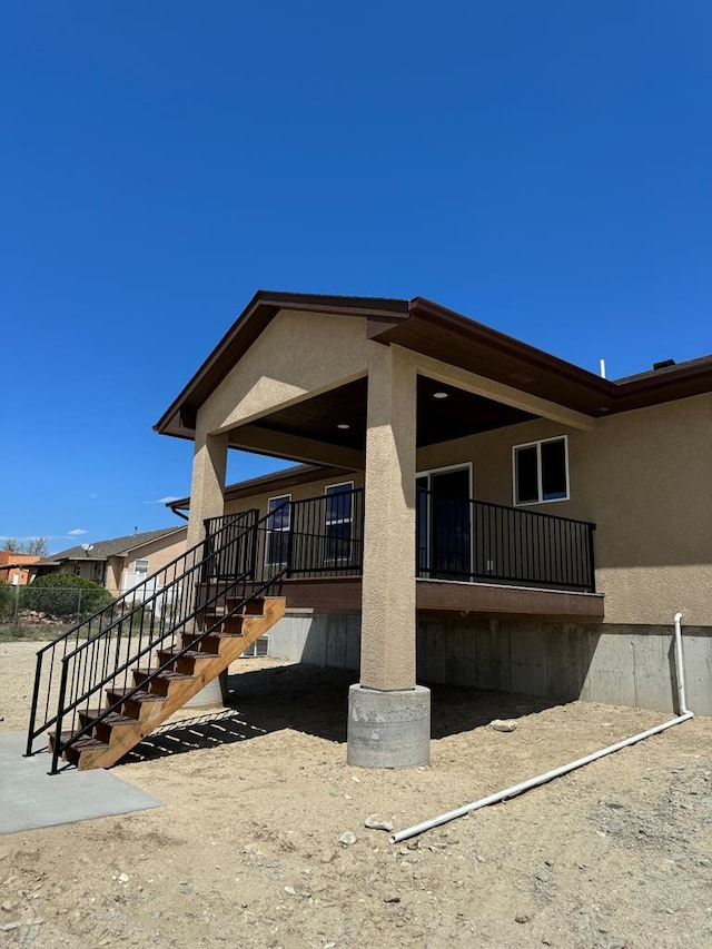 exterior space featuring stairs and stucco siding