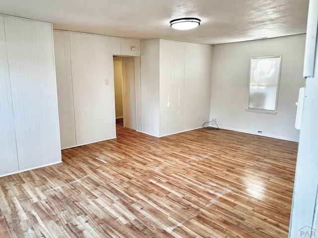 spare room with a textured ceiling and wood finished floors