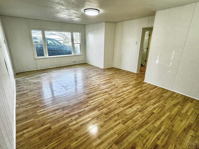 spare room featuring a textured ceiling and wood finished floors