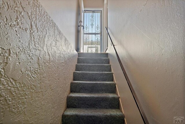 stairs featuring a textured wall