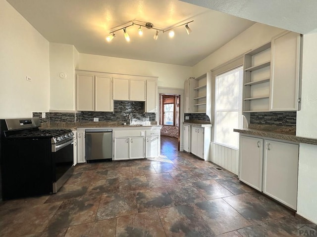 kitchen with stainless steel appliances, dark countertops, white cabinetry, and open shelves