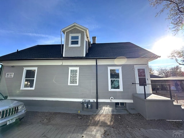 back of property featuring a shingled roof