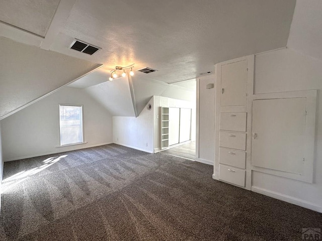 bonus room featuring carpet, visible vents, lofted ceiling, and a textured ceiling