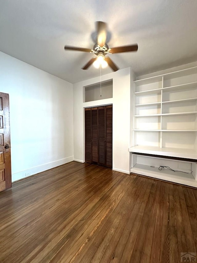 unfurnished bedroom with a closet, dark wood-style flooring, baseboards, and a ceiling fan