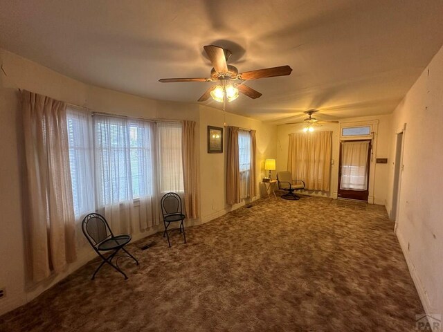 unfurnished room featuring a ceiling fan and carpet flooring