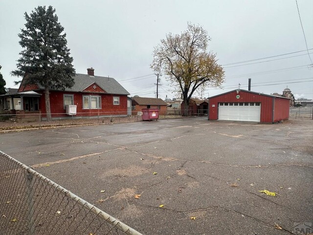 exterior space with a garage, an outbuilding, and fence