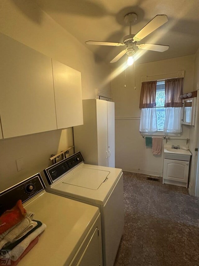 clothes washing area with washing machine and dryer, ceiling fan, and a sink