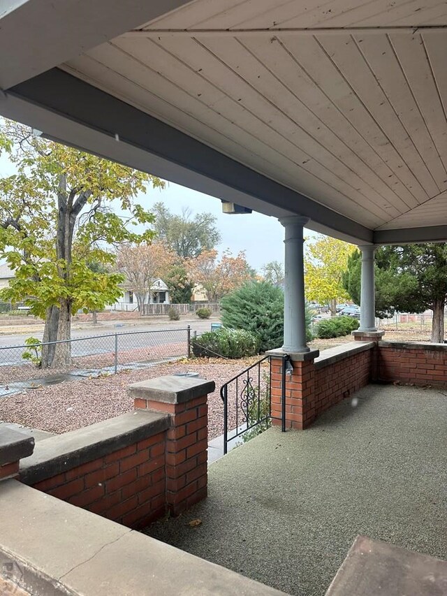 view of patio / terrace featuring a porch and fence