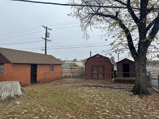 view of yard with fence, an outdoor structure, and a shed