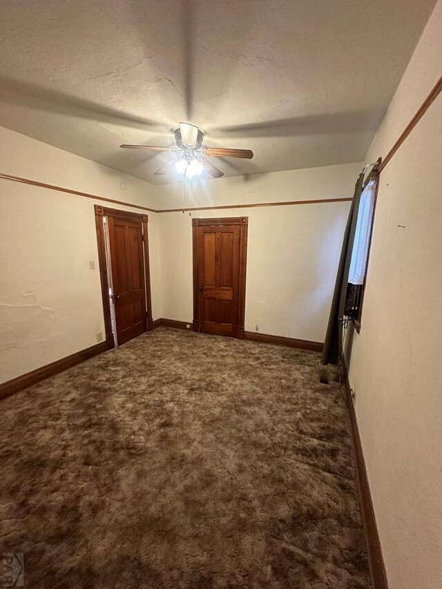 unfurnished bedroom featuring a textured ceiling, carpet, a ceiling fan, and baseboards