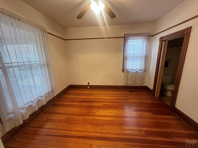 interior space with ceiling fan, wood finished floors, and baseboards