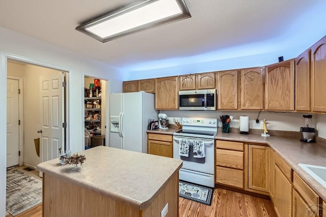 3603 Bobcat Ln, Pueblo, CO 81005 - kitchen featuring white appliances, light wood-type flooring, a kitchen island, light countertops, and a sink