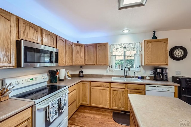 3603 Bobcat Ln, Pueblo, CO 81005 - kitchen featuring white appliances, a sink, light countertops, and light wood finished floors