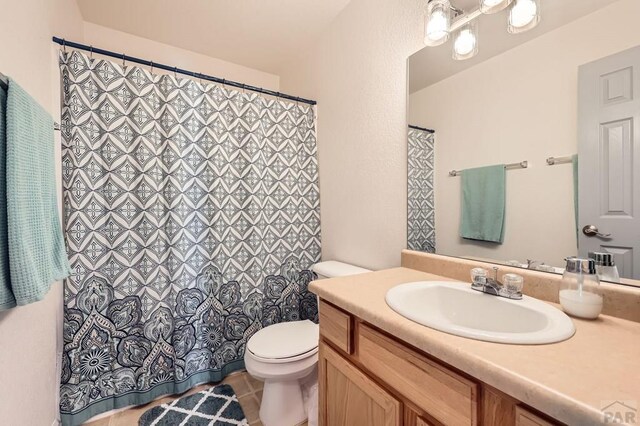 3603 Bobcat Ln, Pueblo, CO 81005 - full bathroom featuring toilet, tile patterned floors, vanity, and curtained shower
