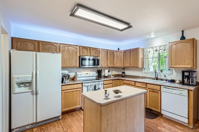 3603 Bobcat Ln, Pueblo, CO 81005 - kitchen featuring white appliances, a sink, light wood-type flooring, a center island, and light brown cabinetry