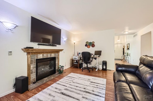 3603 Bobcat Ln, Pueblo, CO 81005 - living area with an office area, wood finished floors, a tile fireplace, and baseboards