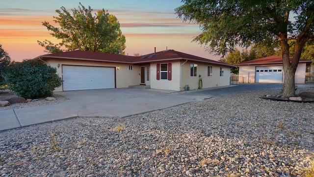 ranch-style home with a garage, concrete driveway, and stucco siding