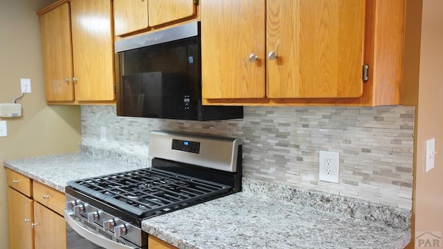 kitchen featuring brown cabinetry and gas stove