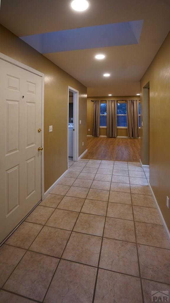 hall featuring light tile patterned floors, recessed lighting, and baseboards