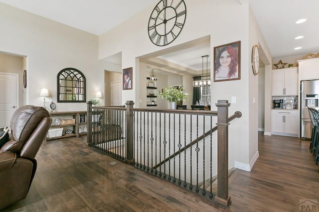 corridor featuring baseboards, an upstairs landing, recessed lighting, and dark wood finished floors
