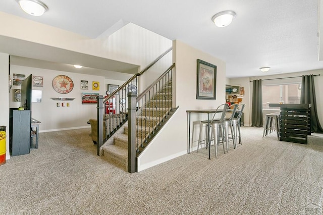 staircase with baseboards and carpet floors
