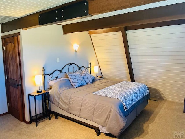 carpeted bedroom with beam ceiling and baseboards