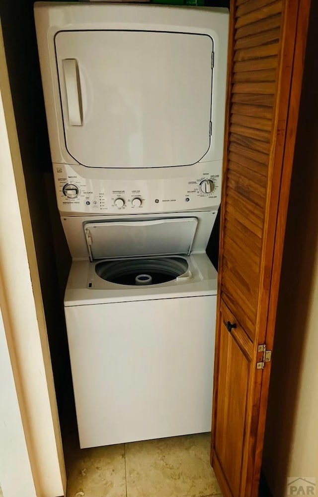 clothes washing area featuring laundry area and stacked washing maching and dryer