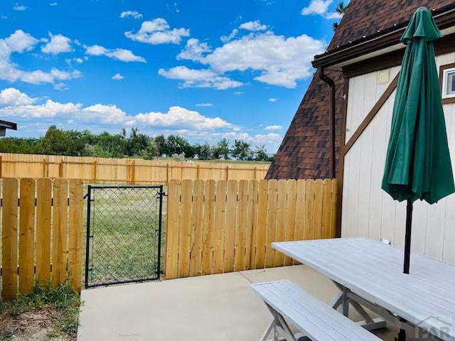 view of patio featuring fence and a gate