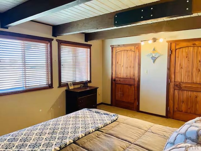 bedroom featuring wooden ceiling, baseboards, and beamed ceiling