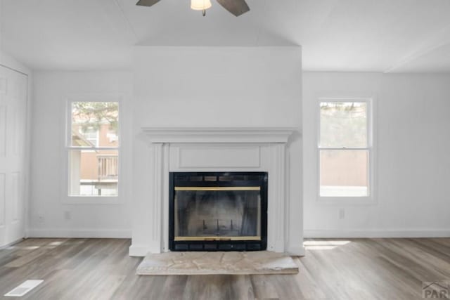 400 Hickory St Unit 172, Fort Collins, CO 80524 - interior details with a ceiling fan, wood finished floors, baseboards, and a glass covered fireplace