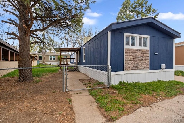 400 Hickory St Unit 172, Fort Collins, CO 80524 - view of side of property with stone siding, a fenced front yard, and a gate