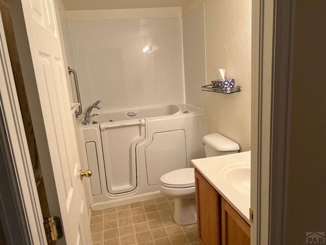 bathroom with vanity, toilet, and a bath