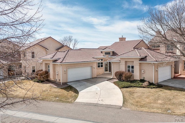 view of front of house with stucco siding, driveway, an attached garage, a chimney, and a tiled roof