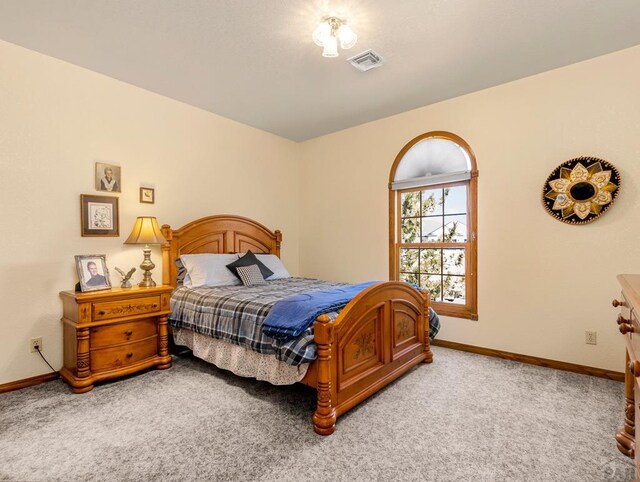 carpeted bedroom featuring visible vents and baseboards