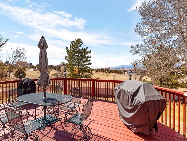 wooden terrace with grilling area and outdoor dining space