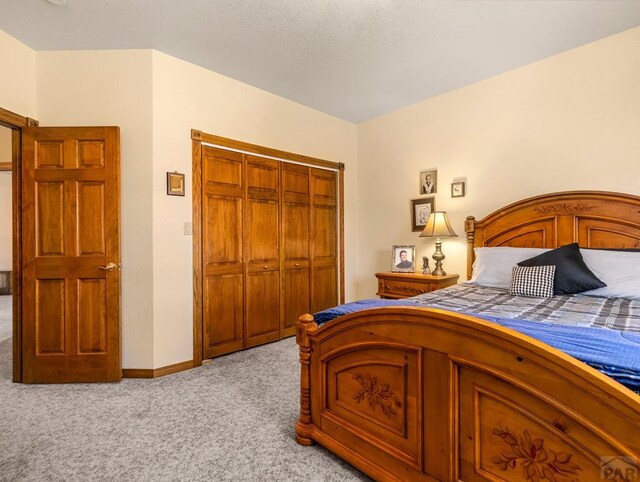 bedroom with light carpet, baseboards, and a closet