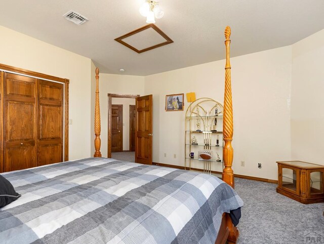 carpeted bedroom featuring attic access, visible vents, and baseboards