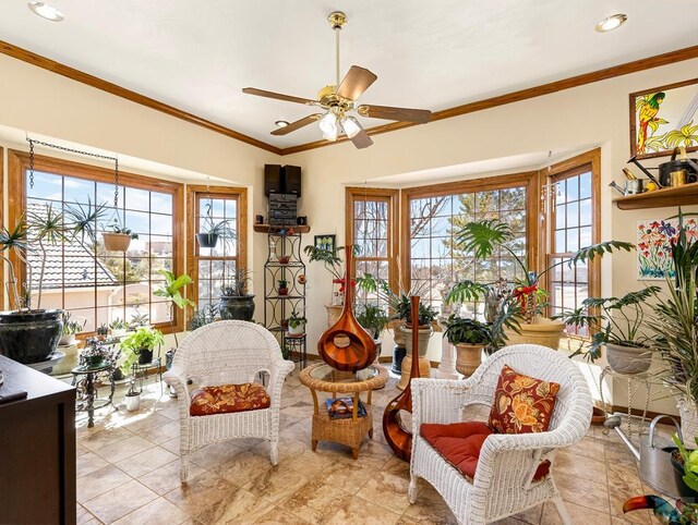 sitting room featuring ornamental molding, a ceiling fan, and baseboards