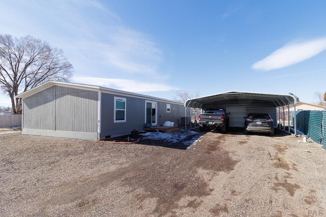 view of front of home featuring a carport, driveway, and fence